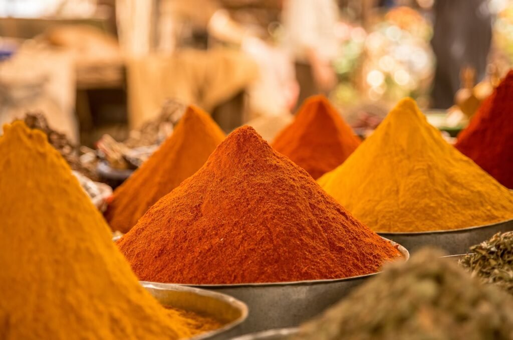 A close-up view of colorful powdered spices on display at a market stall.